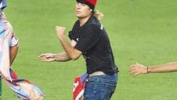 <b>BUSCANDO LA FAMA.</b> El espontáneo interrumpió el partido burlando a la seguridad del estadio, llegó hasta Figo y acabó metido en la red.