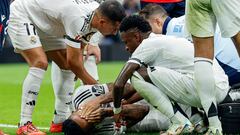Teammates check on Real Madrid's Brazilian defender #03 Eder Militao (bottom) after he sustained an injury during the Spanish league football match between Real Madrid CF and CA Osasuna at the Santiago Bernabeu stadium in Madrid on November 9, 2024. (Photo by OSCAR DEL POZO / AFP)