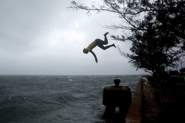 Un hombre se lanza al agua ante la llegada del huracán Melissa en Kingston, Jamaica.