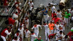 Participants run ahead of bulls during the "encierro" (bull-run) of the San Fermin festival in Pamplona, northern Spain on July 9, 2022. - On each day of the festival six bulls are released at 8:00 a.m. (0600 GMT) to run from their corral through the narrow, cobbled streets of the old town over an 850-meter (yard) course. Ahead of them are the runners, who try to stay close to the bulls without falling over or being gored. (Photo by MIGUEL RIOPA / AFP)
