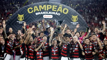 Soccer Football - Brasileiro Championship - Flamengo v Ceara - Estadio Maracana, Rio de Janeiro, Brazil - December 3, 2025 Flamengo's Giorgian de Arrascaeta and Bruno Henrique lift the trophy as they celebrate with teammates after winning the Brasileiro Championship REUTERS/Ricardo Moraes