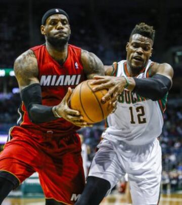 Jeff Adrien (D) y LeBron James (I) luchan por el balón.