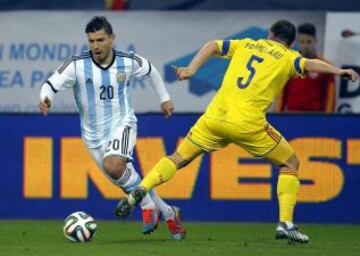 El delantero de la selección argentina, Sergio 'Kun' Agüero (i) lucha por el balón con Alexandru Bourceanu (d) de Rumanía durante el partido amistoso que ambas selecciones disputaron en Bucarest.