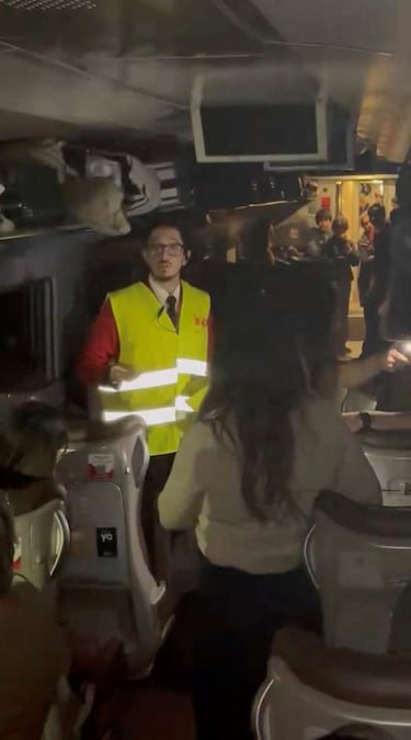Un miembro del personal de emergencias habla con las personas en un vagón del tren, después de que el tren de alta velocidad descarrilara y se estrellara contra otro tren que se aproximaba, cerca de Adamuz, en la provincia de Córdoba, España.