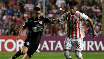 Colombia's Junior Daniel Giraldo (L) and Argentina's Union Santa Fe Juan Carlos Portillo vie for the ball during their Sudamericana Cup group stage first leg football match, at the 15 de Abril stadium in Santa Fe, Argentina, on April 6, 2022. (Photo by Jose ALMEIDA / AFP)