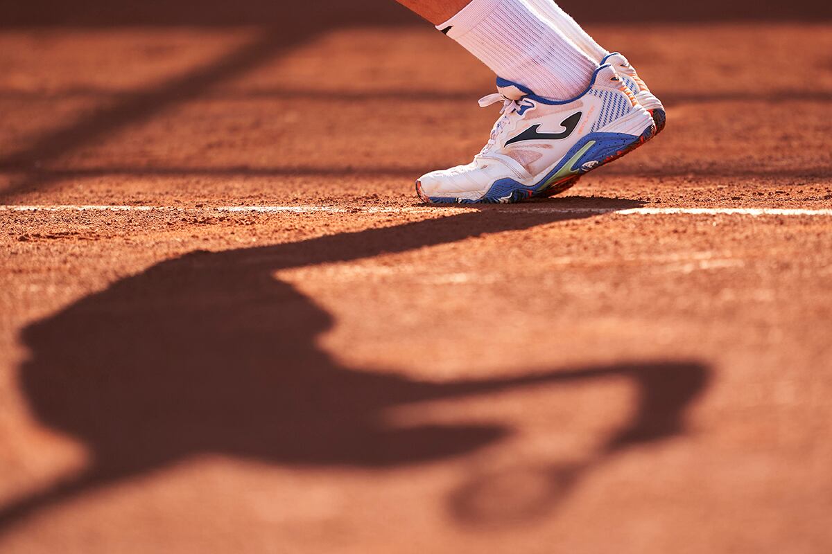 Pies y sombra de tenista.