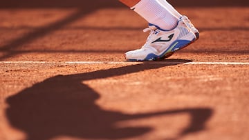 Pies y sombra de tenista.