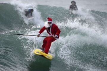 Un hombre vestido como Santa Claus sobre una ola en Varazze, cerca de Génova, aprovechando que el mal tiempo creó buenas olas para el  surf 