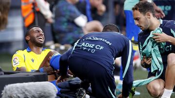 Carlos Akapo, jugador del C&aacute;diz CF, es atendido en la banda por los servicios m&eacute;dicos.