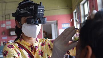 A doctor examines a patient infected with Black Fungus or scientifically known as Mucormycosis, a deadly fungal infection, at a civil hospital in Ahmedabad on May 23, 2021. (Photo by SAM PANTHAKY / AFP)