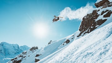 Léo Slemett de front flip en la nieve durante un dia soleado