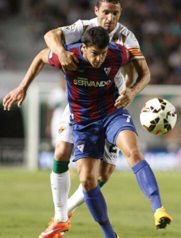 El centrocampista del Eibar, Ader Capa (delante), controla el balón ante la presión del defensa del Elche, Edu Albácar (detrás), durante el encuentro de la cuarta jornada de Liga de Primera División que se juega esta noche en el estadio Martínez Valero, en Elche.