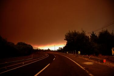 Vista de una carretera vacía mientras el fuego y el humo se elevan de un incendio forestal en la región del Biobío, donde, según medios locales, múltiples incendios forestales provocaron evacuaciones de emergencia, en Concepción, Chile.