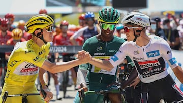 UAE Team Emirates team's Slovenian rider Tadej Pogacar wearing the overall leader's yellow jersey shakes hands with Soudal Quick-Step team's Belgian rider Remco Evenepoel wearing the best young rider's white jersey (R) as Intermarche - Wanty team's Eritrean rider Biniam Girmay wearing the sprinter's green jersey (C) looks at the start of the 20th stage of the 111th edition of the Tour de France cycling race, 132,8 km between Nice and Col de la Couillole, southeastern France, on July 20, 2024. (Photo by Anne-Christine POUJOULAT / AFP)