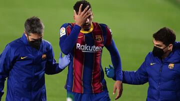 Barcelona&#039;s Uruguayan defender Ronald Araujo (C) reacts as he is escorted off the pitch during the Spanish league football match between Real Betis and FC Barcelona at the Benito Villamarin stadium in Seville on February 7, 2021. (Photo by CRISTINA Q