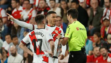 El delantero del Rayo Vallecano Raúl de Tomas (c) habla con el árbitro de Burgos Bengoetxea (d) durante el partido de la jornada 28 de Liga en Primera División que Atlético de Madrid y Rayo Vallecano juegan hoy domingo en el estadio de Vallecas. EFE/MARISCAL