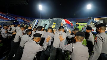 Agentes de policía empujan un vehículo dañado mientras lo sacan del estadio Kanjuruhan, donde se produjeron disturbios y estampidas tras un partido de fútbol entre Arema y Persebaya, en Malang.