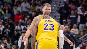 Los Angeles Lakers forward LeBron James (23) jokes with forward/guard Luka Doncic (77) after a shot against the New Orleans Pelicans during the second half at Smoothie King Center.