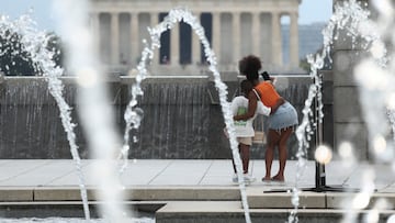 Visitors pose for a selfie beside the fountain at the World War II Memorial, with the Lincoln Memorial in the background, amid a dangerous heat wave afflicting the eastern half of the United States, in Washington, D.C., U.S., June 25, 2025. REUTERS/Kevin Lamarque