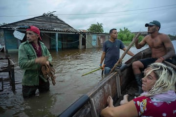 Vecinos conversan en una calle inundada tras el paso del huracán Helene en Guanimar, provincia de Artemisa, Cuba.