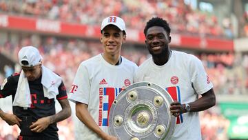 Cologne (Germany), 27/05/2023.- Bayern Munich's Jamal Musiala (L) and Alphonso Davies (R) pose with the league title trophy after winning the German Bundesliga soccer match between 1.FC Cologne and FC Bayern Munich, in Cologne, Germany, 27 May 2023. Bayern Munich won the title due to a better goal difference. (Alemania, Colonia) EFE/EPA/ANNA SZILAGYI CONDITIONS - ATTENTION: The DFL regulations prohibit any use of photographs as image sequences and/or quasi-video.
