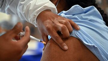 An indigenous woman is inoculated with the Johnson & Johnson vaccine against COVID-19 at a vaccination centre in La Paz, on August 2, 2021. - Second doses for people vaccinated over 90 days ago with the Russian vaccine against COVID-19 Sputnik V have not arrived yet in Bolivia. (Photo by AIZAR RALDES / AFP)