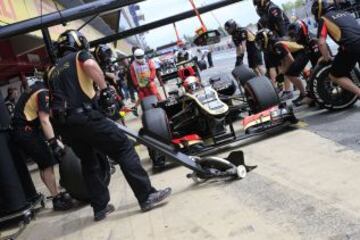 Los boxes del equipo Lotus F1 a pleno rendimiento cambiando los neumáticos en el coche del piloto francés Romain Grosjean.