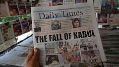 A man holds a newspaper displaying front page news about Afghanistan, at a stall in Islamabad on August 16, 2021.