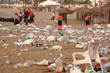 Miembros del servicio de limpieza municipal de M¨¢laga recogen restos de basura en la playa de La Malagueta.