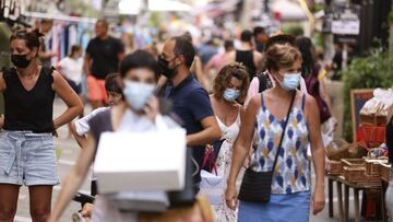 People wearing protective face masks shop along Fesch street in Ajaccio's touristic district on August 4, 2021, as health officials activated an emergency plan on the Mediterranean island of Corsica as a fourth wave of Covid infections spread across