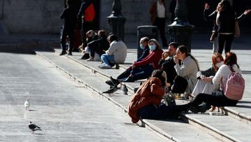 GRAFCVA1878. VALENCIA, 16/02/2021.--Un grupo de jóvenes almuerzan al sol en la Plaza de la Virgen de Valencia cuando todavía siguen en vigor el cierre de la hostelería para bajar la alta incidencia de contagios por Covid-19 en la Comunitat Valenciana.".EFE/ Kai Försterling