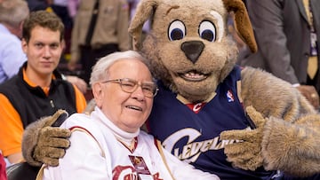 Warren Buffet juega con la mascota de los Cleveland Cavaliers, Moon Dog, antes del partido contra los Charlotte Hornets durante la primera mitad en el Quicken Loans Arena el 15 de diciembre de 2014 en Cleveland, Ohio.