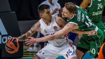 GRAF4366. MADRID, 25/02/2021.- El alero argentino del Real Madrid Gabriel Deck (i) lucha con Marius Grigonis, del Zalgiris Kaunas, durante el partido de la fase regular de la EuroLiga que Real Madrid y Zalgiris Kaunas juegan hoy jueves en el WiZink Center, en Madrid. EFE/JuanJo Martín.