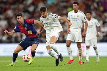 Real Madrid's Spanish defender #35 Raul Asencio fights for the ball with Barcelona's Polish forward #9 Robert Lewandowski during the Spanish Super Cup final football match between Real Madrid and Barcelona at the King Abdullah Sport City in Jeddah on January 12, 2025. (Photo by Haitham AL-SHUKAIRI / AFP)