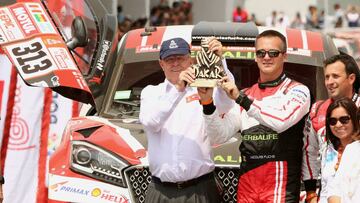 Dakar Rally - 2018 Peru-Bolivia-Argentina Dakar rally - 40th Dakar Edition - January 6, 2018 -  Peruvian President Pedro Pablo Kuczynski holds a present next to Borgward Rally team driver Nicolas Fuchs of Peru on the podium during the departure ceremony in Lima, Peru. REUTERS/Mariana Bazo