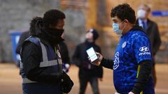 LONDON, ENGLAND - DECEMBER 16: Fans show their Covid-19 passes to stewards outside the stadium prior to the Premier League match between Chelsea and Everton at Stamford Bridge on December 16, 2021 in London, England. (Photo by Mike Hewitt/Getty Images)