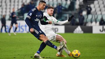 TURIN, ITALY - JANUARY 10: Cristiano Ronaldo of Juventus F.C.  scores their team&#039;s third goal under pressure from Georgios Kyriakopoulos of Sassuolo during the Serie A match between Juventus and US Sassuolo at Allianz Stadium on January 10, 2021 in T