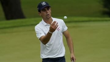Chile's Joaquin Niemann catches his ball after it was cleaned by his caddie on the second green during the first round of the men's golf event at the 2020 Summer Olympics on Wednesday, July 28, 2021, at the Kasumigaseki Country Club in Kawagoe, Japan. (AP Photo/Matt York)