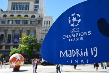 People walk past a sign for the UEFA Champions League final football match between Liverpool and Tottenham Hotspur in Madrid on May 29, 2019. 
