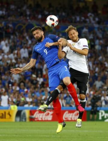 Giroud jumps for the ball with German defender Shkodran Mustafi.