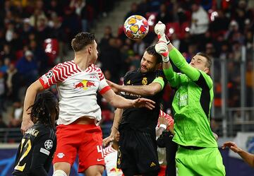 El guardameta del Real Madrid despeja de puños el lanzamaiento de un córner. Nacho Fernández salta con el portero ucraniano ante la mirada del jugador del Leipzig, Willi Orban.