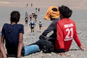 Varias personas observan el paso de los corredores durante la primera etapa de la 35ª edición de la Marathon des Sables, entre Borj Irdi y Tisserdimine, al sur de Marruecos. Se trata de una carrera de extrema dureza, de 250 km repartidos en seis etapas, que discurre por el desierto del Sahara, uno de los lugares más inhóspitos del mundo.