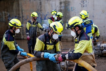 Los bomberos trabajan para limpiar las aguas residuales de las inundaciones provocadas por las fuertes lluvias en Massanassa, Valencia.