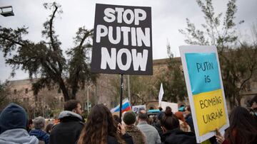Demonstrators hold signs reading "Putin is bombing Ukraine" and "Stop Putin Now" during a protest against Russia's military operation in Ukraine, in Barcelona on February 26, 2022.