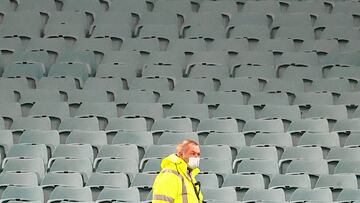 A security guard wears a face mask in front of an empty stand before the start of the the Super Rugby match between the NSW Waratahs and Queensland Reds at the Sydney Cricket Ground (SCG) on August 8, 2020. (Photo by DAVID GRAY / AFP)