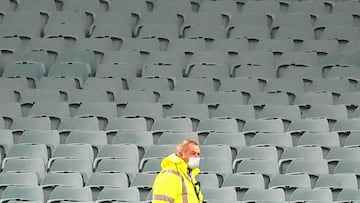 A security guard wears a face mask in front of an empty stand before the start of the the Super Rugby match between the NSW Waratahs and Queensland Reds at the Sydney Cricket Ground (SCG) on August 8, 2020. (Photo by DAVID GRAY / AFP)