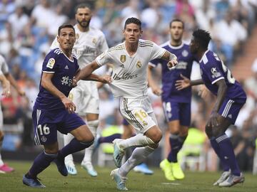 El jugador del Real Valladolid, San Emeterio, y el jugador del Real Madrid, James Rodríguez, se agarran durante una acción del partido. 