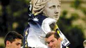 <b>LOS DOS HÉROES.</B> Zidane y Casillas, dos de los héroes de la Novena, miran ayer sobre La Cibeles la Copa de Europa conseguida ante el Bayer.