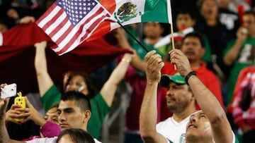 Un aficionado ondea las banderas de México y Estados Unidos.