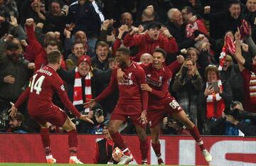 Liverpool's Dutch midfielder Georginio Wijnaldum (C) celebrates with Liverpool's English midfielder Jordan Henderson (L) and Liverpool's English defender Trent Alexander-Arnold after scoring their third goal during the UEFA Champions league semi-final sec